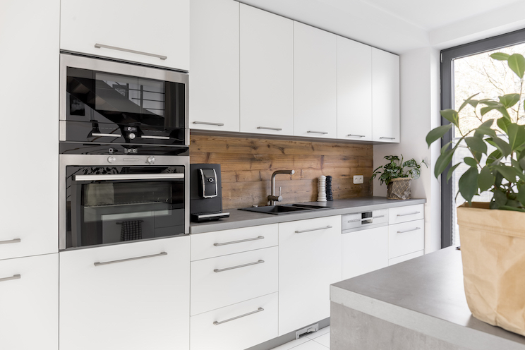Balanced kitchen with white cabinets grey worktop and natural accents