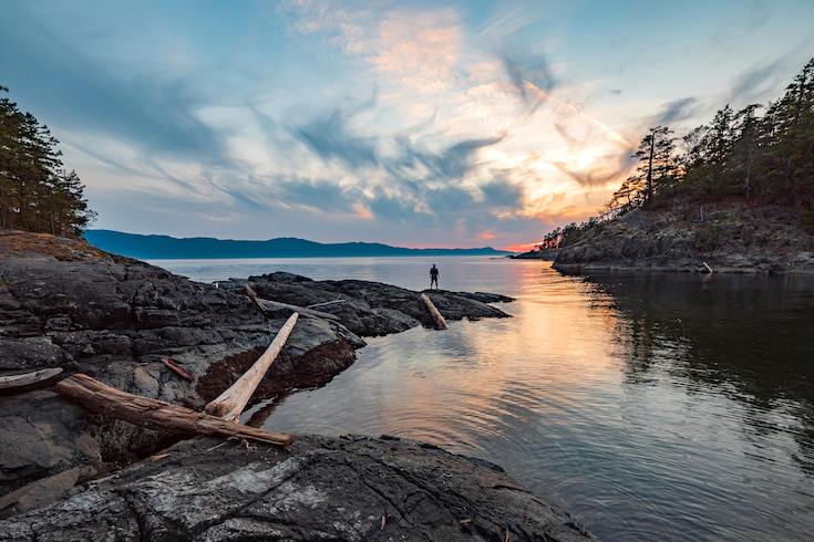 Man standing by the edge of the ocean in the Gulf Islands, BC