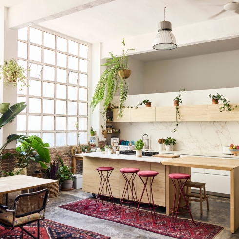 Add or Update Stools and Chairs tools arranged by kitchen island. Interior of apartment with furniture. Houseplants are near window.