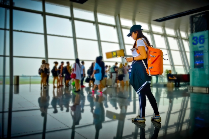 woman traveler passenger in motion of urgent hurry to find-out the gate way terminal to check-in boarding pass