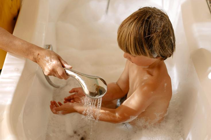 A Boy Taking a Bath in a Bathtub
