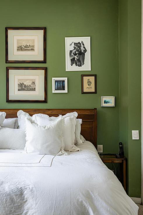 White Sheets in Cozy Home Bedroom with vintage framed art on a green wall