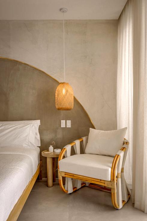 Cozy Modern Bedroom with Rattan Chair and Lamp and a white bed with an oversized headhead